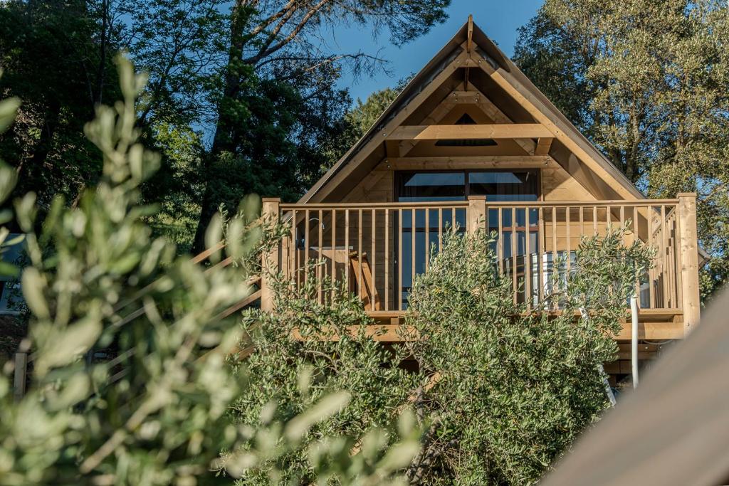 a cabin with a deck and trees at Glamping Pagliaini in Riparbella