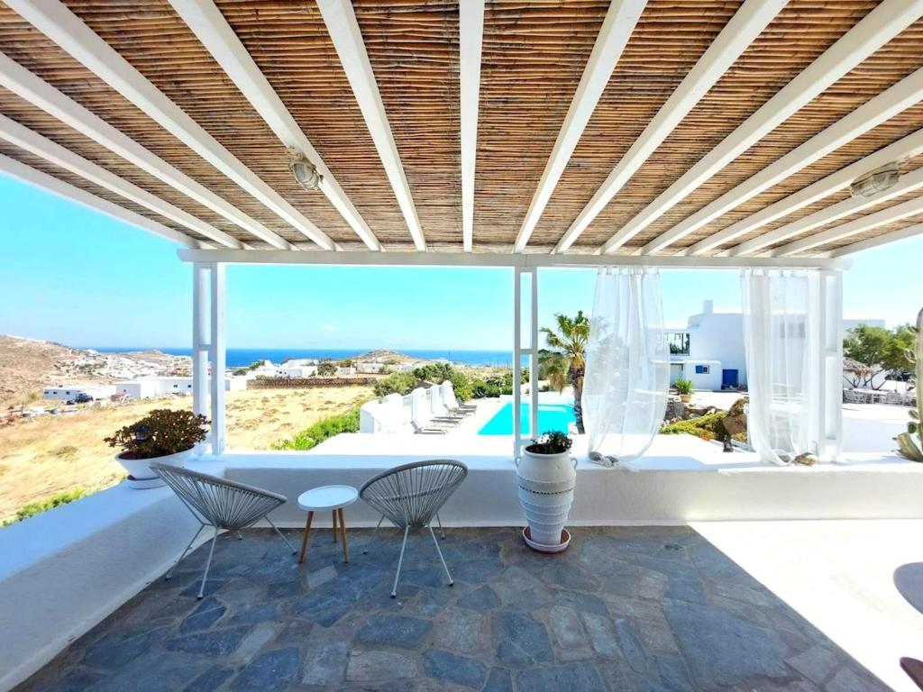 a patio with a table and chairs and a view of the ocean at Paraga Meltemi View in Platis Gialos
