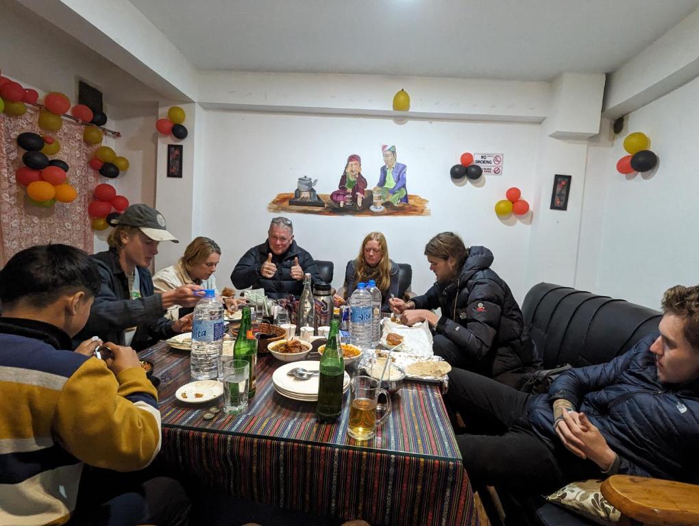 a group of people sitting around a table eating at Mochilero B&B in Darjeeling