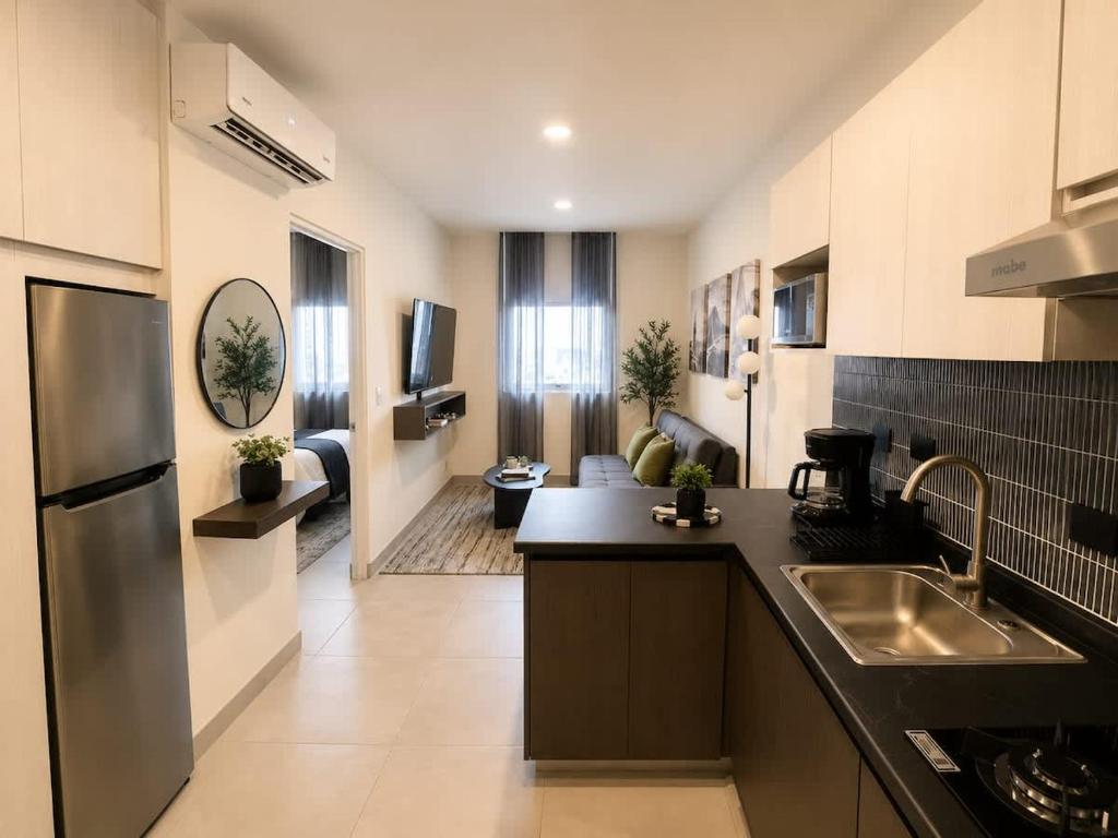 a kitchen with a sink and a living room at FIFA Monterrey Stay in Monterrey