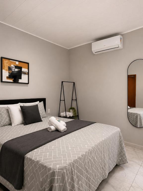 a bedroom with a large bed and a mirror at Brisamar Suítes Ilha Grande in Angra dos Reis