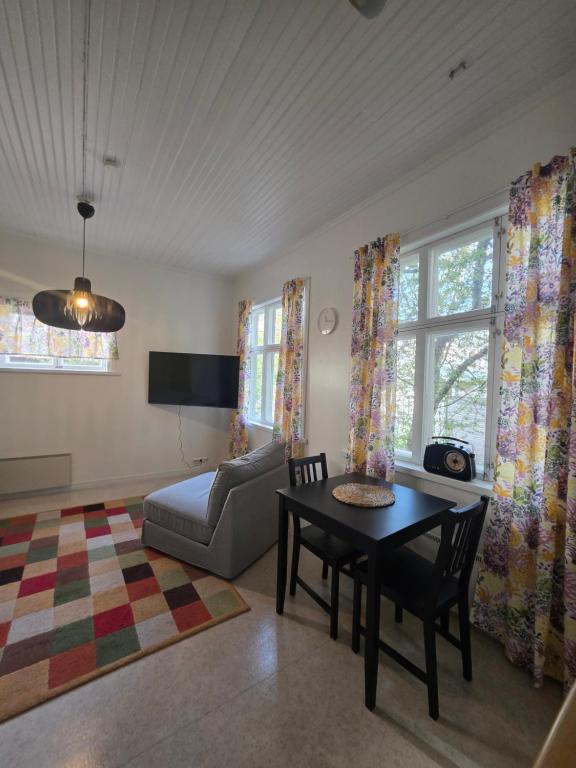 a living room with a table and a couch at Huoneisto Majakka in Kokkola