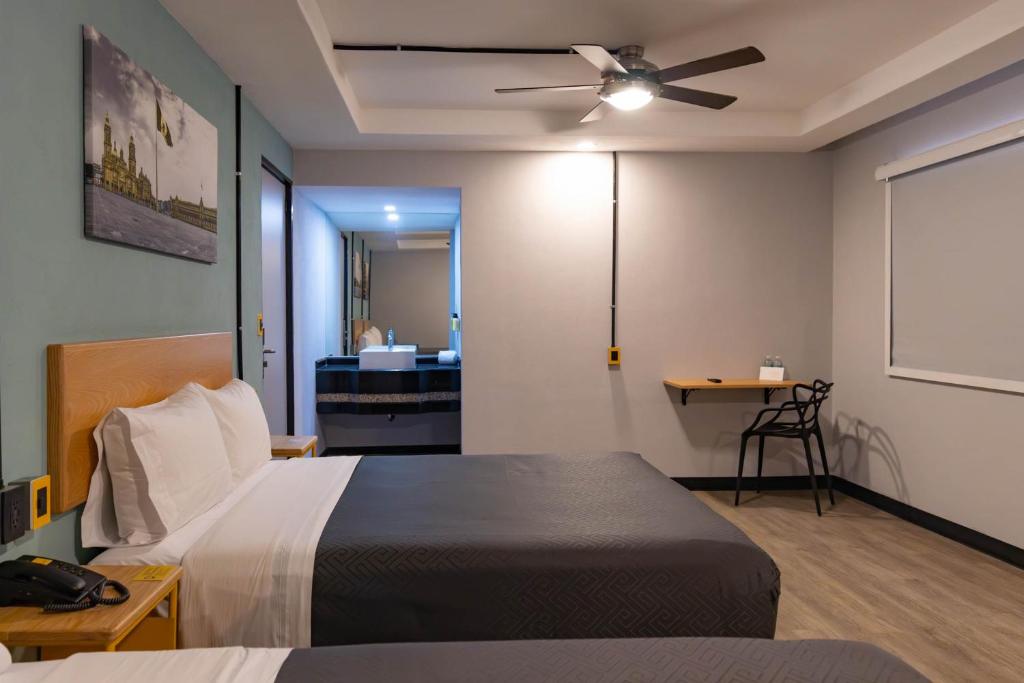 a bedroom with a bed and a ceiling fan at Hotel Escala Centro Histórico in Mexico City
