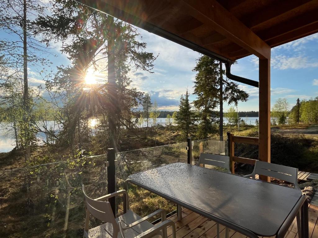 a table and chairs on a screened in porch with the sunset at Villa Light in Ruka