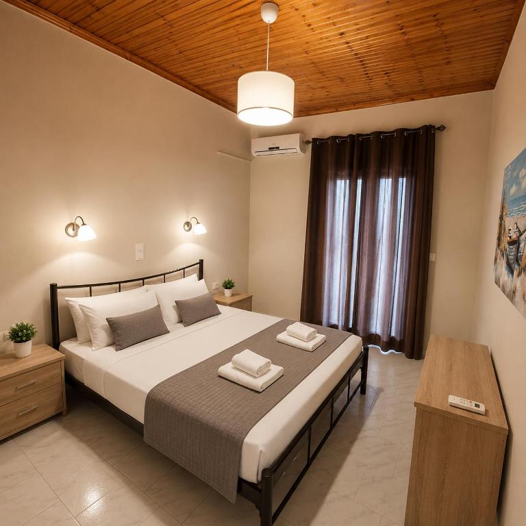 a bedroom with a large bed with two towels on it at Villa Yannis 1 in Roda