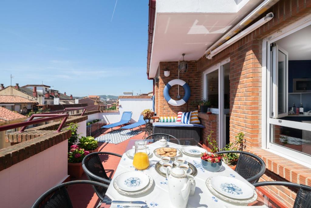 a table on a balcony with a view of the water at Ático La Mallera in Luanco