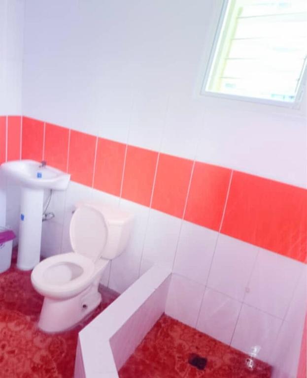 a bathroom with a white toilet and a sink at C24 guesthouse in Cap-Haïtien