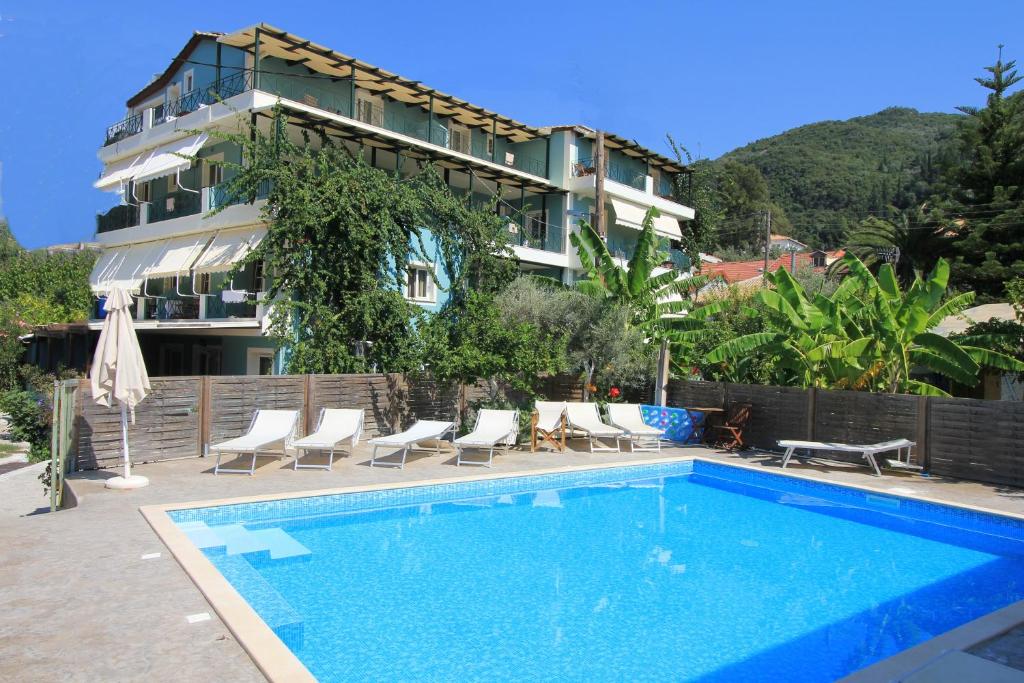 a hotel with a swimming pool in front of a building at Vassiliki Bay Hotel in Vasiliki