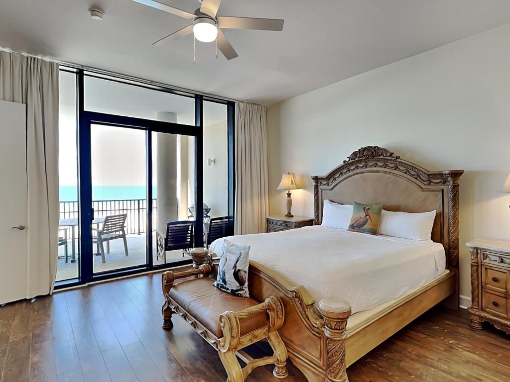 a bedroom with a large bed and a balcony at Capri #301 in Perdido Key
