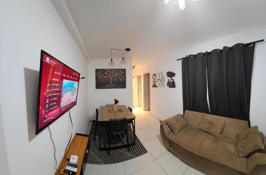a living room with a couch and a flat screen tv at Apartamento completo no Bérgamo in Feira de Santana