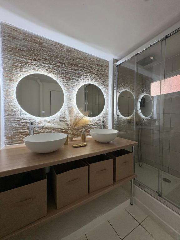 a bathroom with two sinks and two mirrors at Appartement ALYA in Les Trois-Îlets