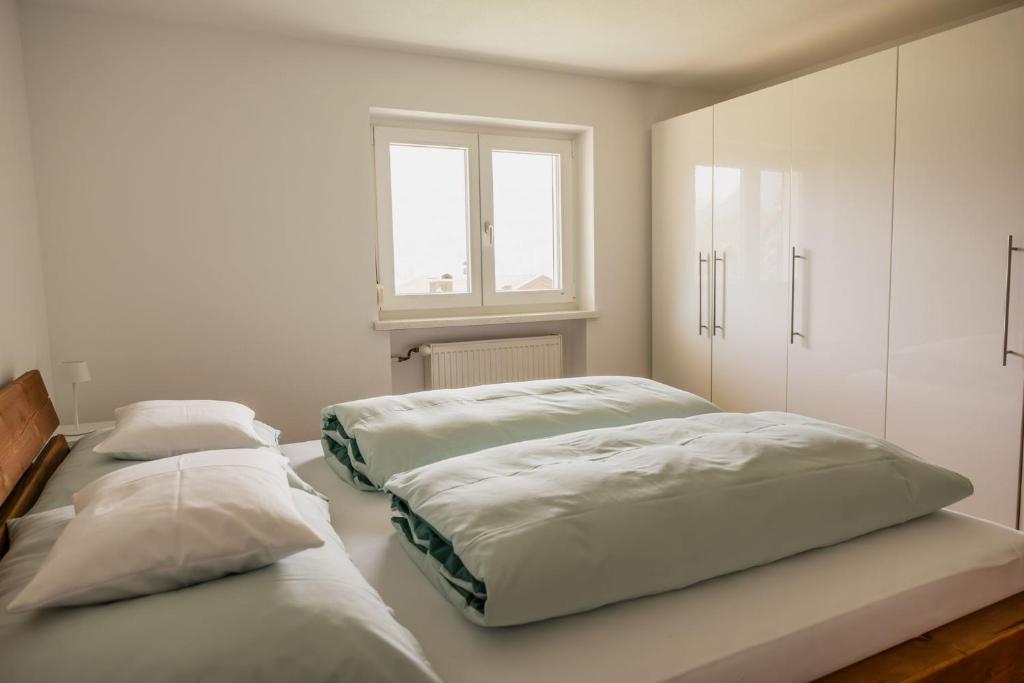 two beds in a white room with a window at Haus Hermann in Schruns