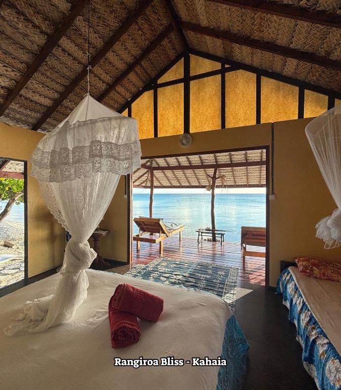 ein Schlafzimmer mit Bett und Meerblick in der Unterkunft Rangiroa Bliss in Tiputa