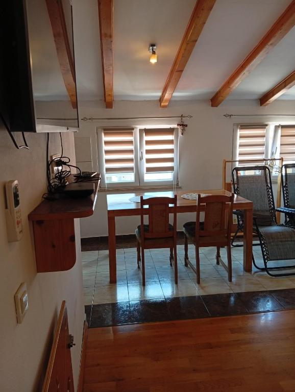 a dining room with a table and chairs and windows at Studio Mare in Kaštela
