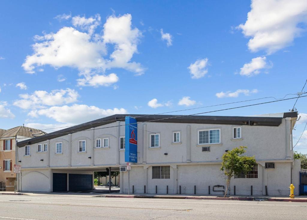 a white building with a blue sign on the side of it at Studio 6 Rosemead, CA in Rosemead