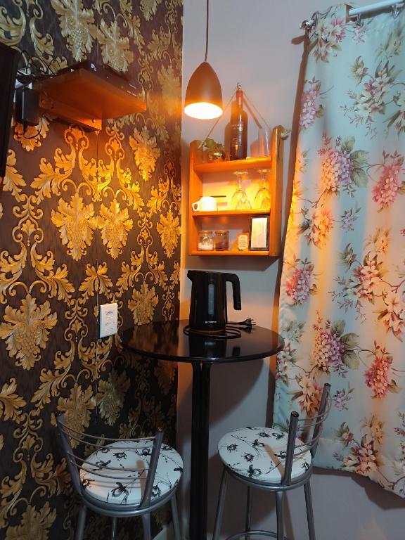 a table with two chairs and a coffee maker on it at Pousada Estrela Do Luar in Urubici