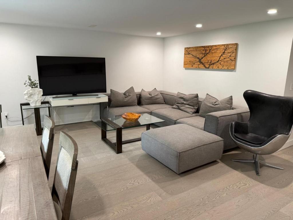 a living room with a couch and a flat screen tv at 2BDRM-Kitchenette-BBQ-Smart TV-4-5Guest in West Vancouver