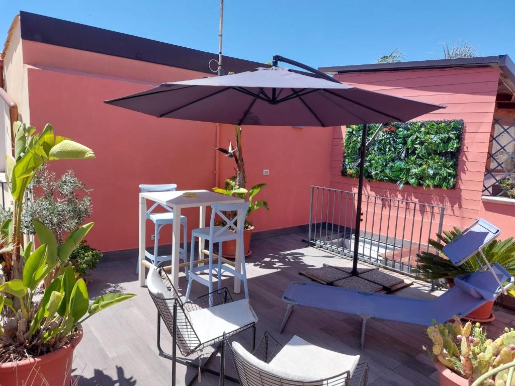 a patio with an umbrella and a table and chairs at Galena Charme Luxury Terrace in Syracuse