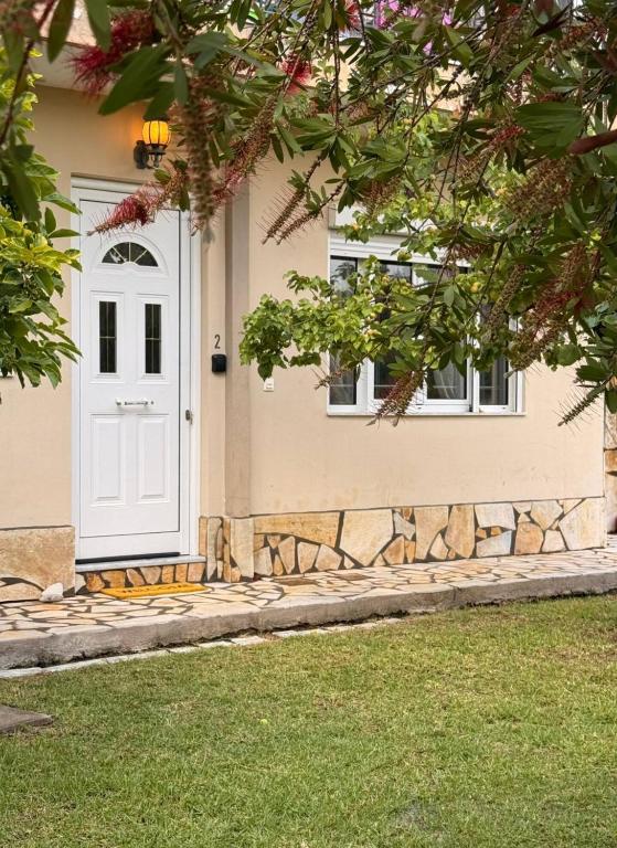 a house with a white door and two windows at SunKipos in Paleros