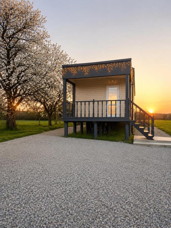 a house with a porch on a gravel driveway at Panorama Hrytsulivka in Vorokhta