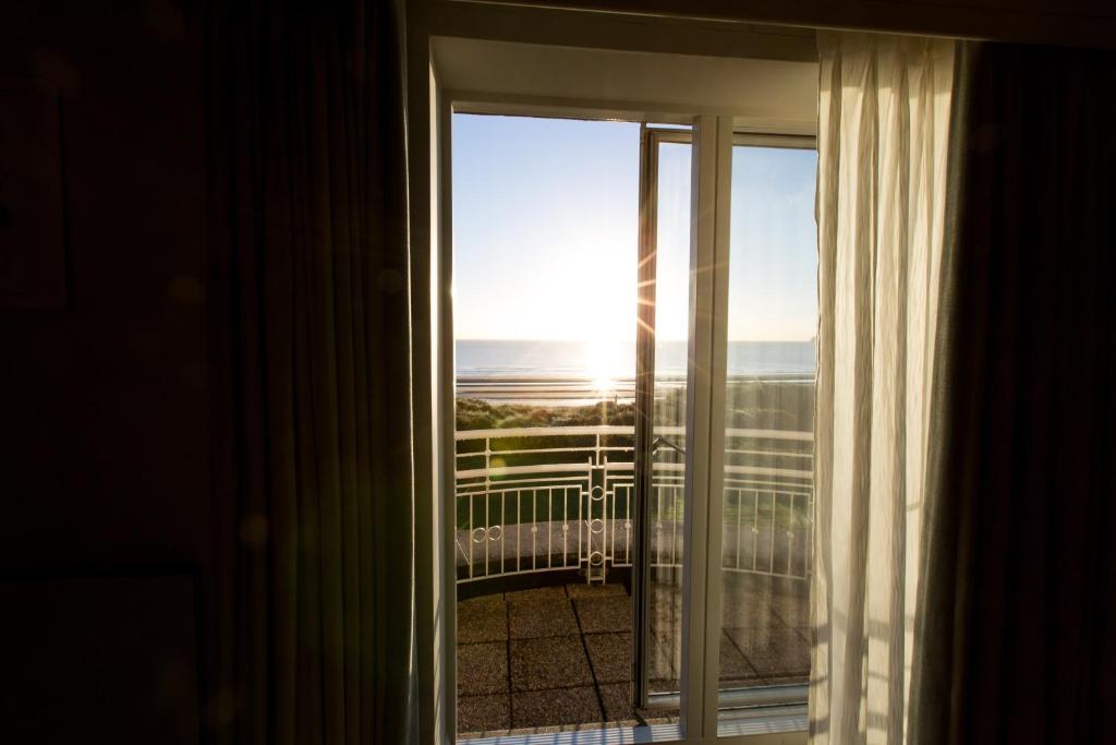 a room with a window with a view of the ocean at Portmarnock Resort & Jameson Golf Links in Portmarnock