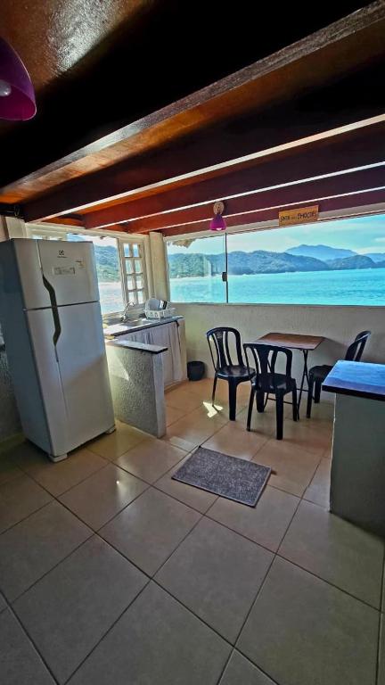 a kitchen with a table and chairs and a refrigerator at Bem Me Quer - Hospedagem in Trindade