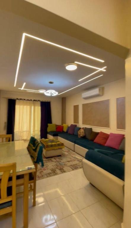 a living room with a couch and a table at مارينا دلتا Alpha star in ‘Izbat Abū Sulayman
