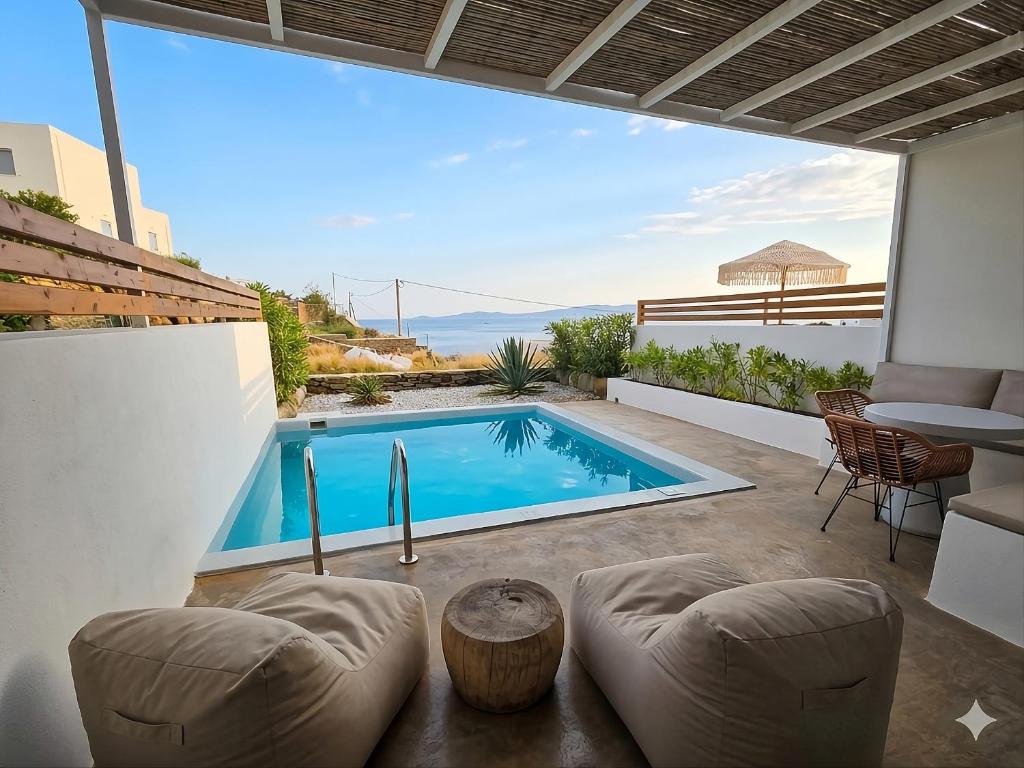 a swimming pool in a villa with a table and chairs at Aura Sun Villa in Agios Romanos