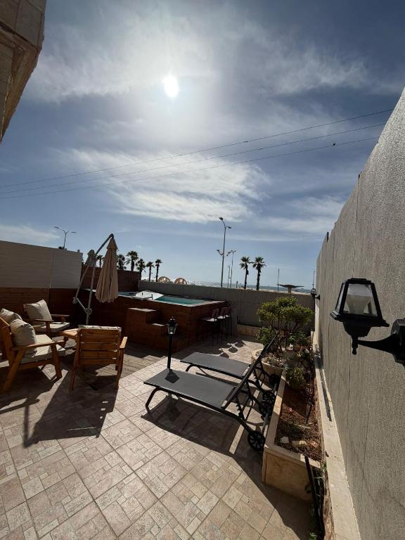 a patio with chairs and a table and a pool at SeaSide Villa in Ashdod