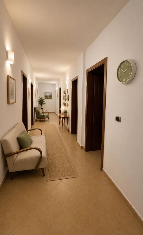 a living room with a couch and a clock on a wall at Vacation house villa roni in Durrës