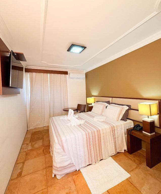 a hotel room with a bed and a television at Akirá Pousada in Aquiraz