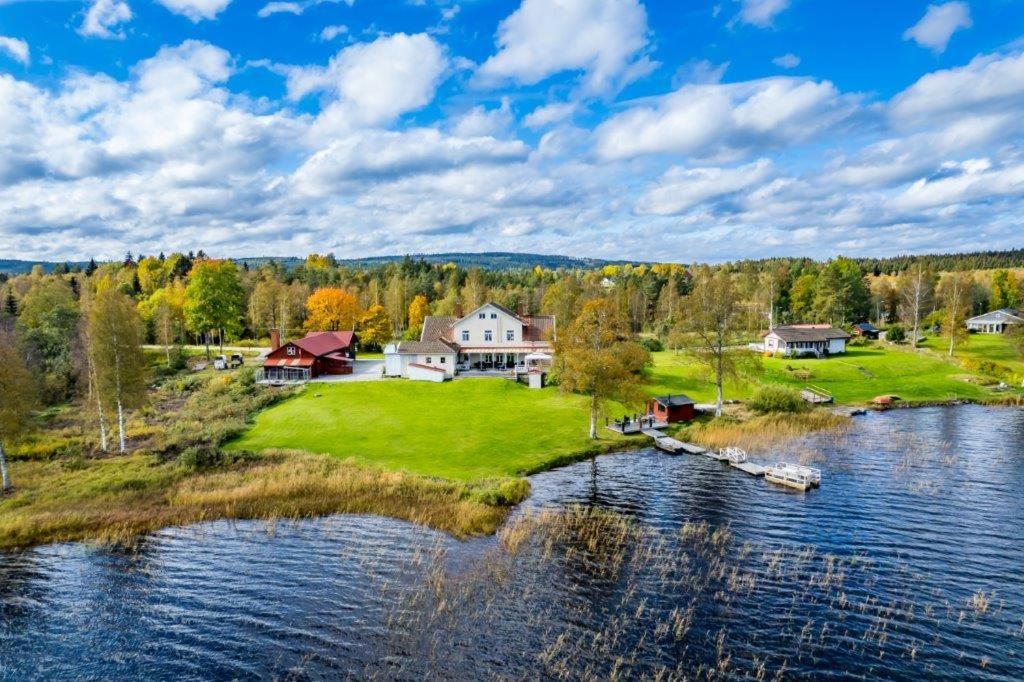 an island in the middle of a lake with houses at Udden Retreat-Bed & Breakfast in Skinnskatteberg