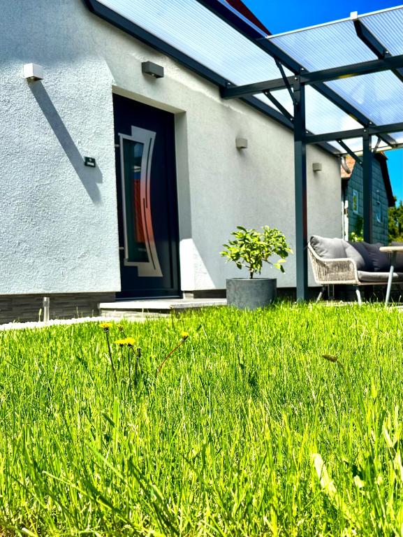 a house with a door and a chair in the grass at Ferienwohnung Rätzlingen in Rätzlingen
