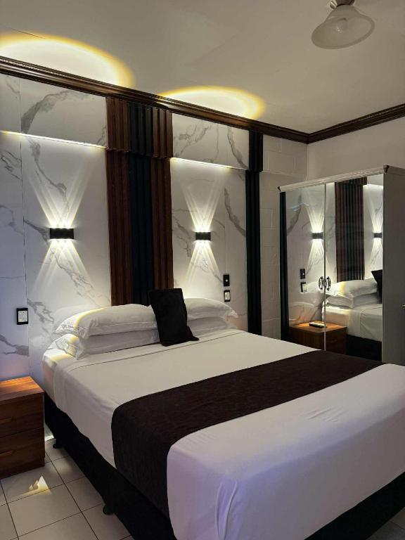 a bedroom with a large bed and two mirrors at Moatoga Hotel in Apia