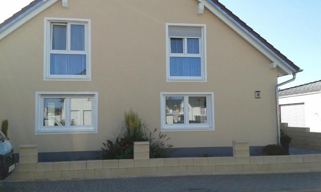ein Haus mit drei Fenstern und einer Auffahrt in der Unterkunft Ferienwohnung Valerie in Ettenheim