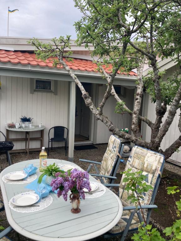 a table with plates and a vase of flowers on it at Lugnt och centralt in Strömstad
