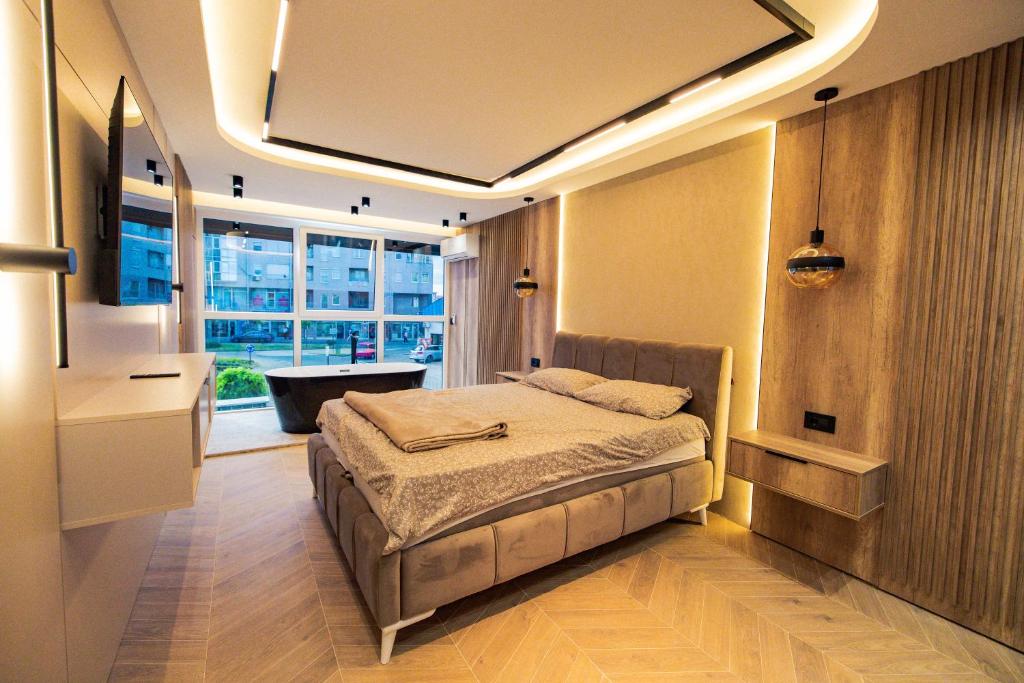 a bedroom with a bed and a large window at AMD LUX apartman in Bijeljina