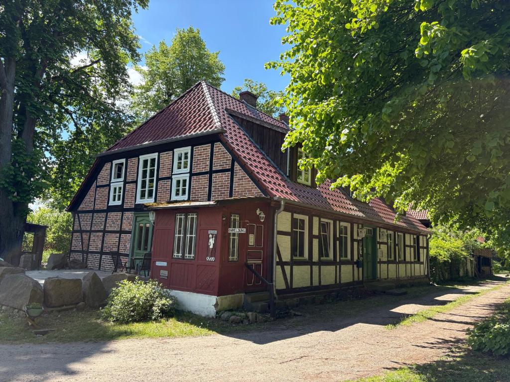 ein kleines rot-schwarzes Haus mit einer roten Tür in der Unterkunft Ferienwohnung Eldeidyll in Neu Kaliß
