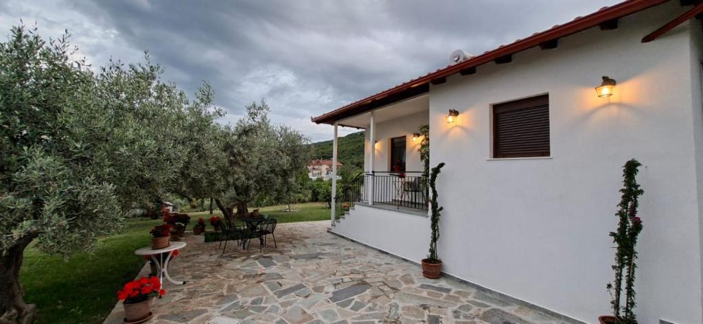 a white house with a patio and trees at Family House in Platamonas