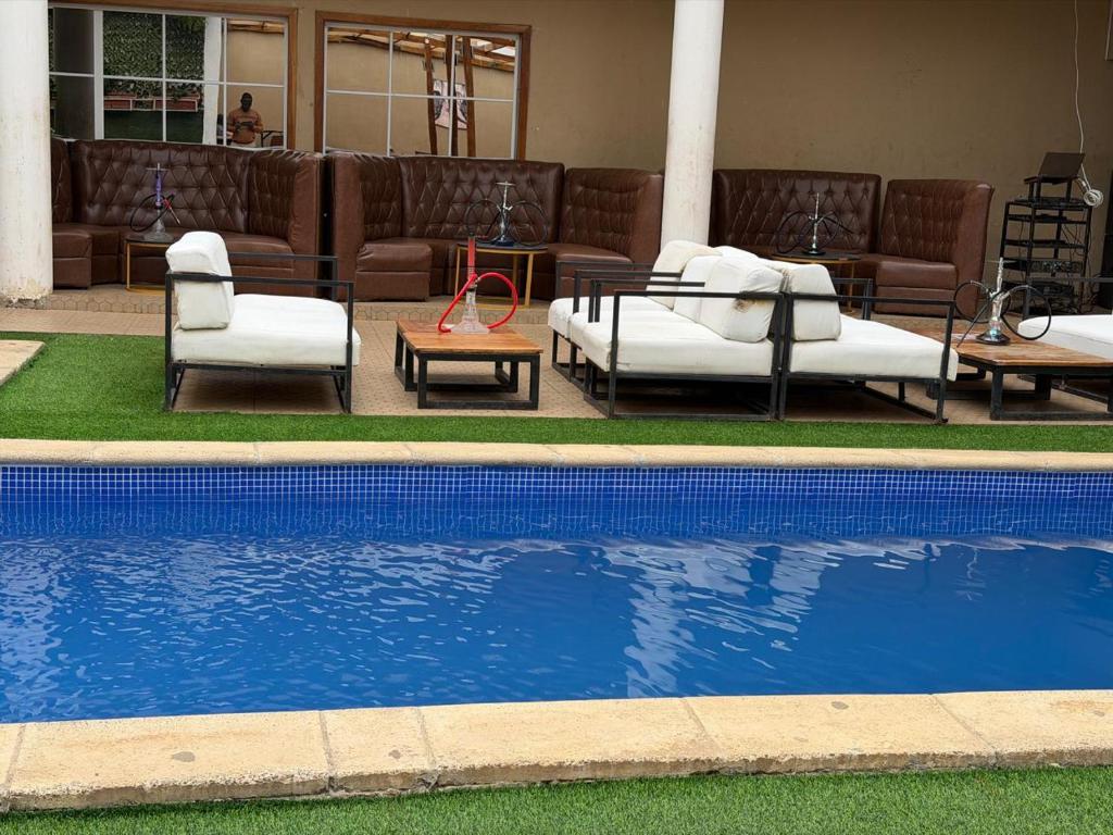 a swimming pool with couches and chairs next to a pool at Residencial Convênios- Hotelaria e Turismo LDA in Luanda