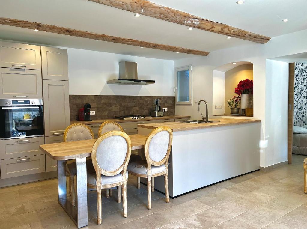 a kitchen with a table and chairs and a sink at Maison plein pied in Sorgues