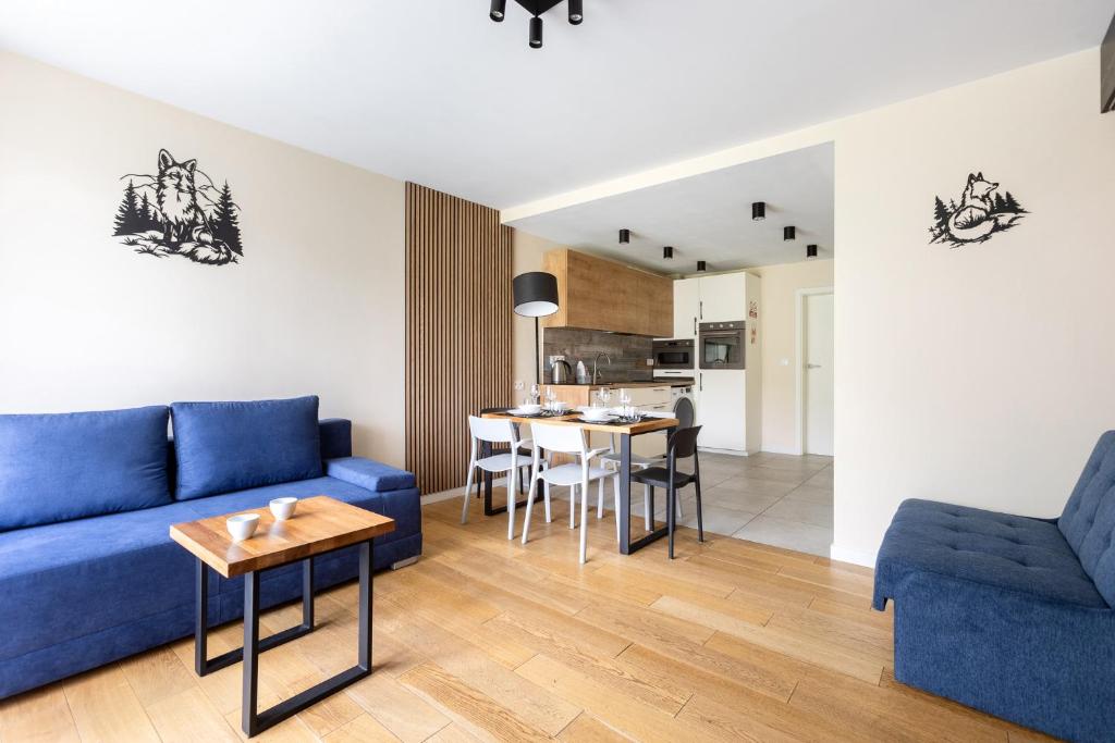 a living room with a blue couch and a table at Apartament z Liskiem Szczyrk przy Żylicy SKI bus narty relaks i natura in Szczyrk
