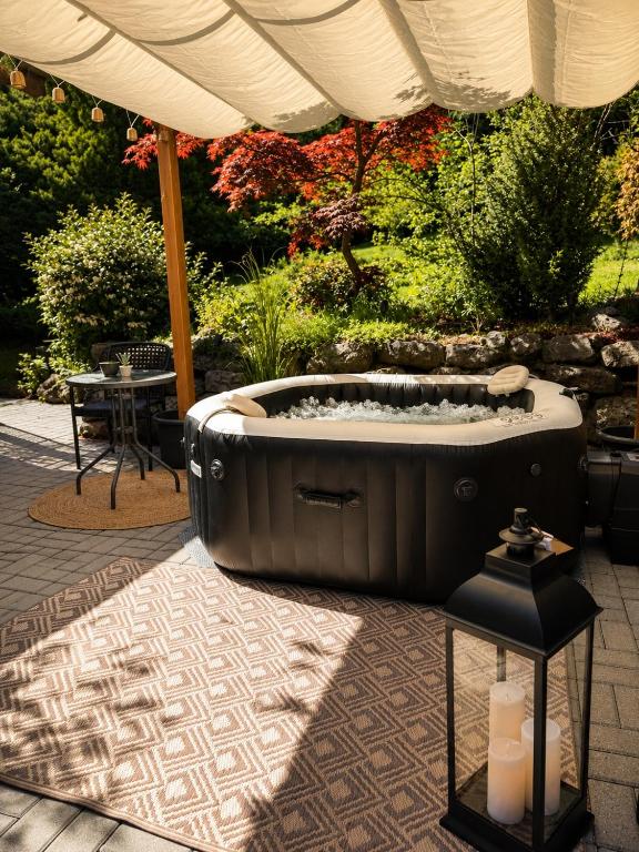 a hot tub sitting under an umbrella on a patio at Wellspace Forest Retreat in Karlovy Vary