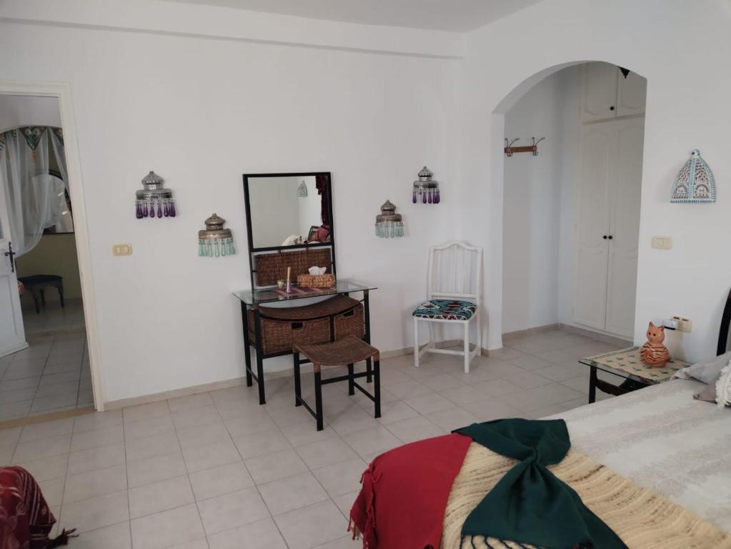 a bedroom with a mirror and a table and a bed at Maison aux Jarres in Midoun