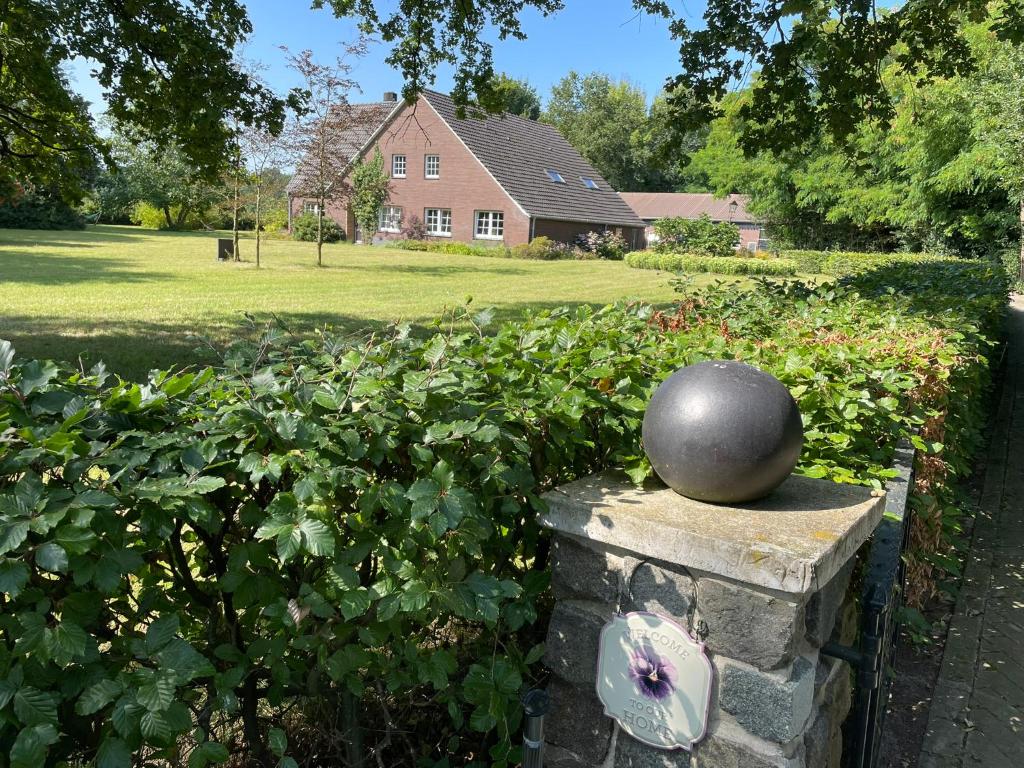 a statue on a stone wall in a yard at Tijd-Loos in Geeste