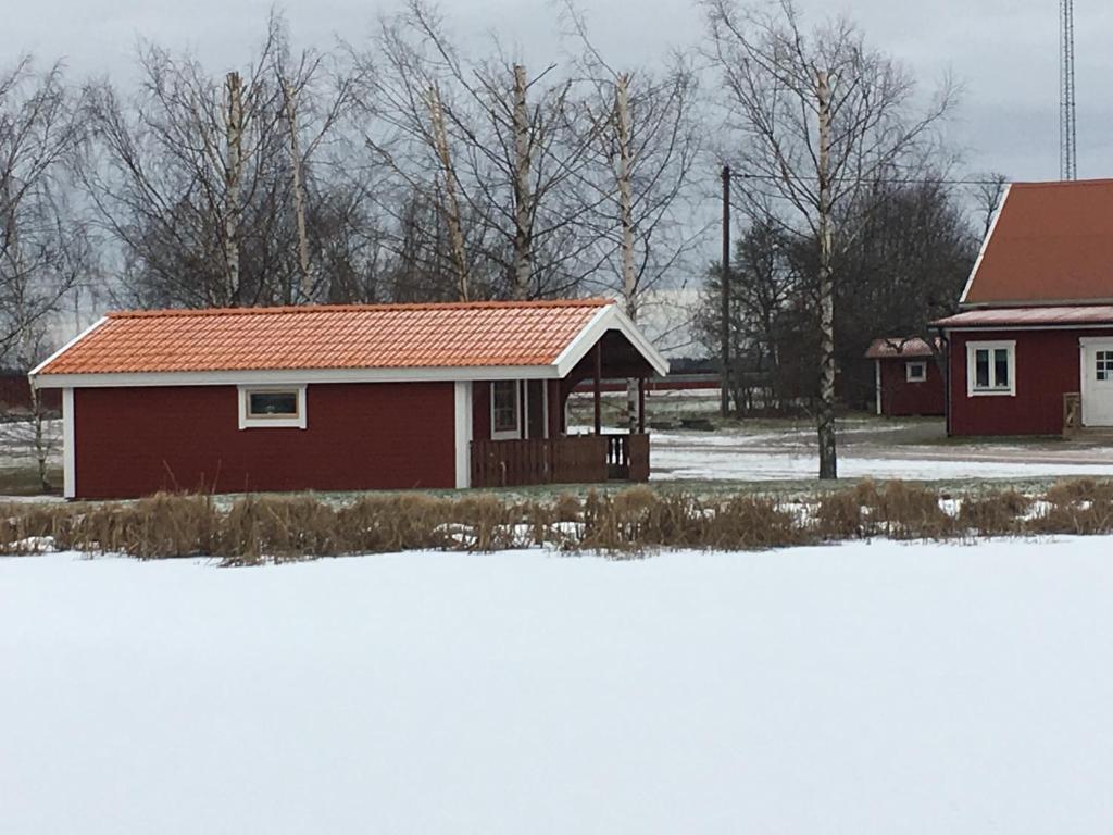una casa roja con techo rojo en la nieve en Gripenbergs Gårdsbutik en Skänninge