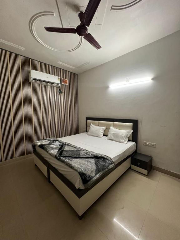 a bedroom with a bed with a ceiling fan at Hotel Triple A in Bhucho