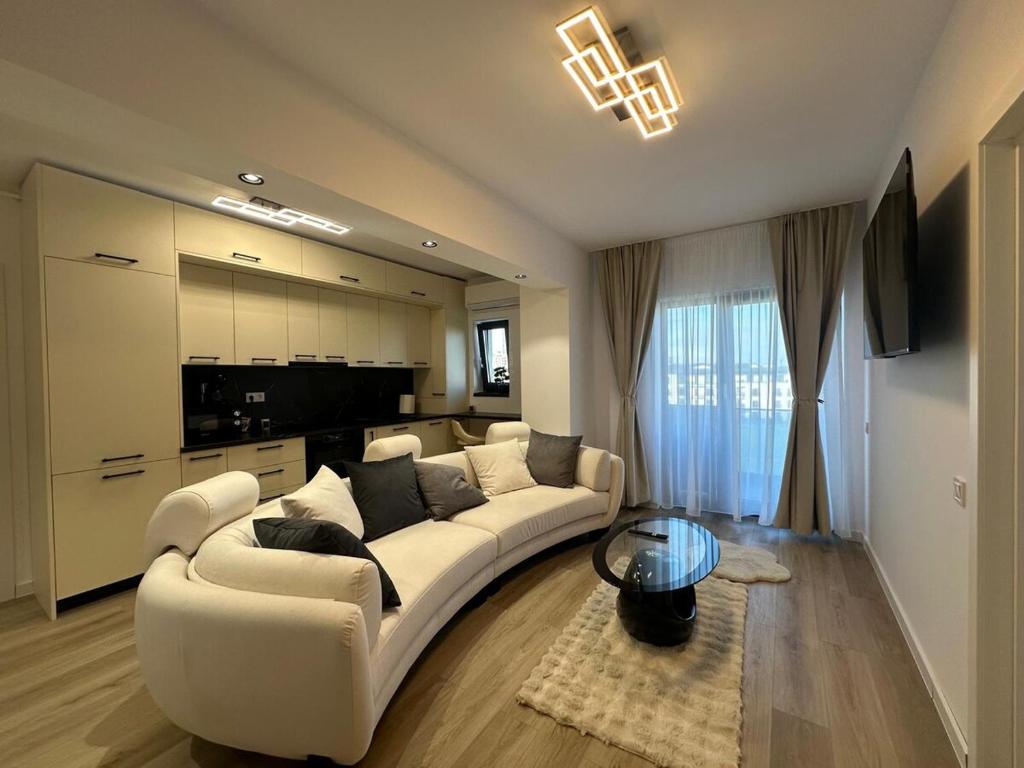 a living room with a white couch and a table at Luxury Vibes in Şelimbăr