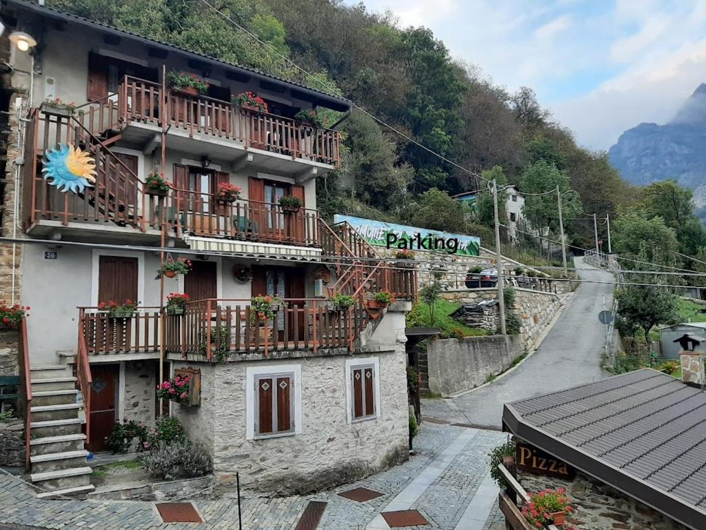 a building with balconies and a sign on the side of it at Sotto il Cielo, Balcone panoramico sul borgo di Ingria in Ingria