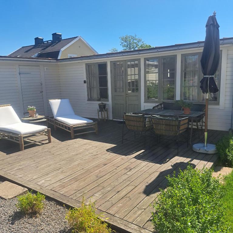 a patio with a table and chairs and an umbrella at Gästhus öppen planlösning in Oskarshamn